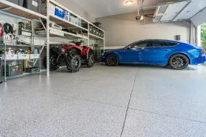 blue car and atv parked in garage with fresh concrete coating floor that is better than epoxy floors