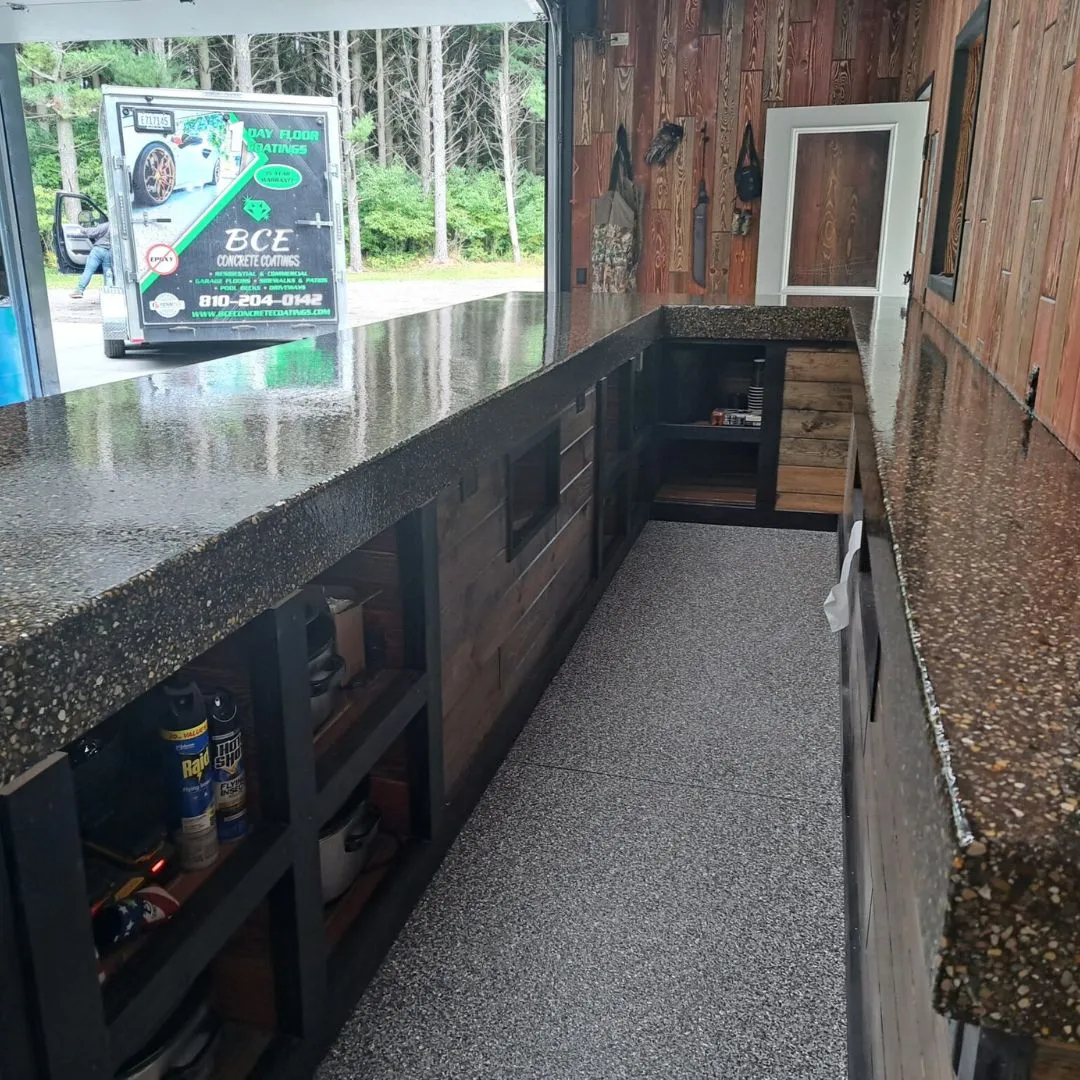 a custom-built bar or counter area, likely for outdoor entertaining or a shed, featuring stone countertops and wooden walls.