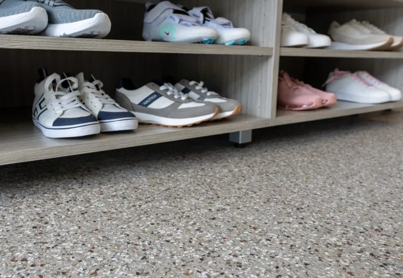 The image displays a selection of sneakers arranged on a wooden shoe rack.
