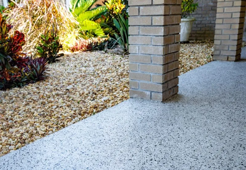 a concrete patio that has been refinished with a modern concrete coating system, such as a polyurea or epoxy floor coating designed to look like exposed aggregate or stone.