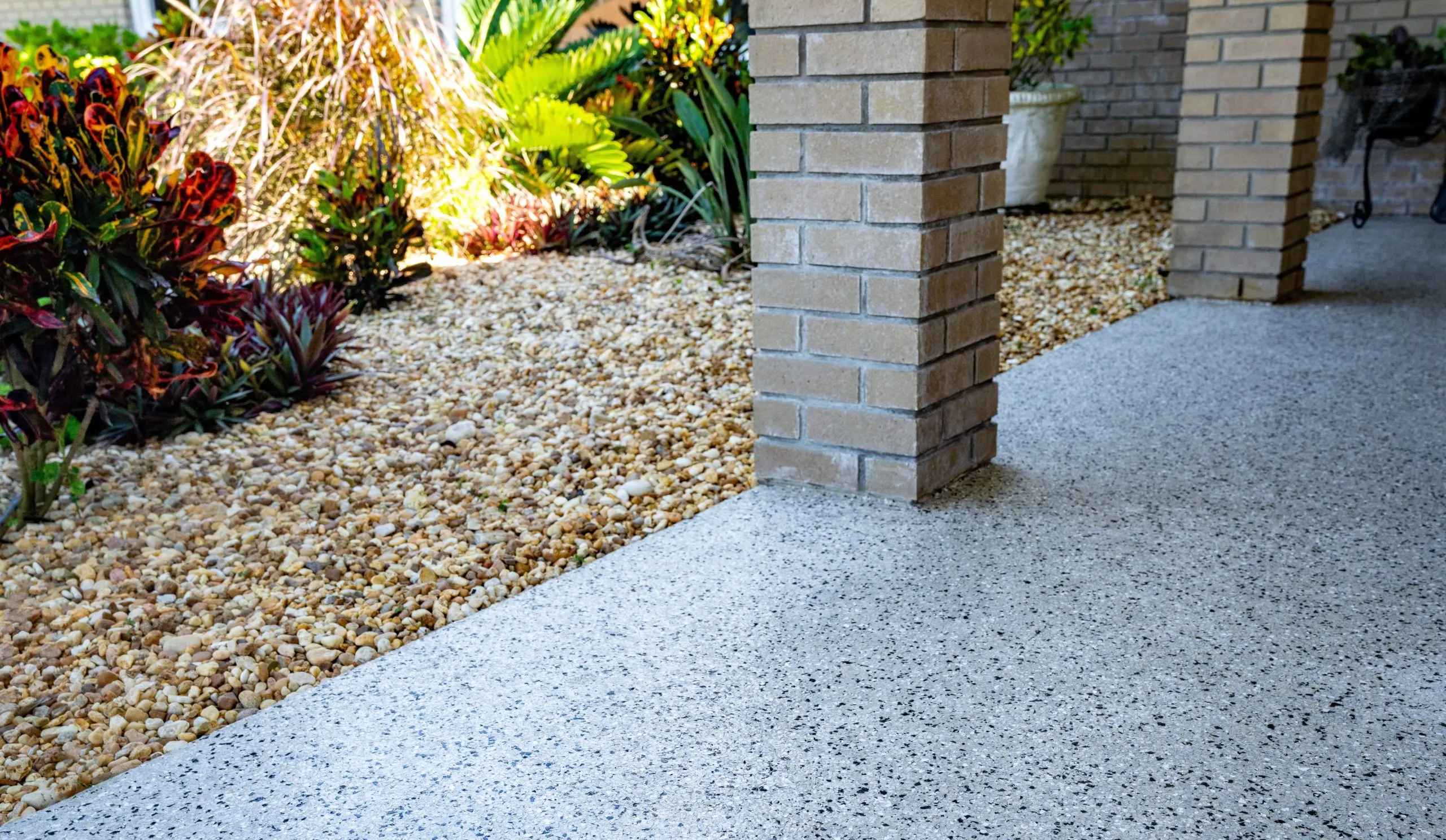 a concrete patio that has been refinished with a modern concrete coating system, such as a polyurea or epoxy floor coating designed to look like exposed aggregate or stone.