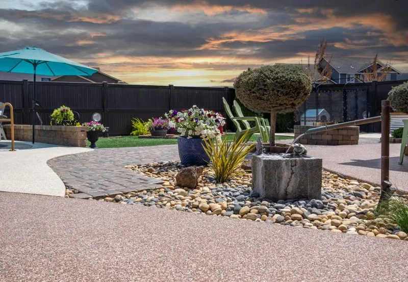 a professionally landscaped patio featuring a modern polyurea concrete coating, designed for durability and a granite-like appearance.