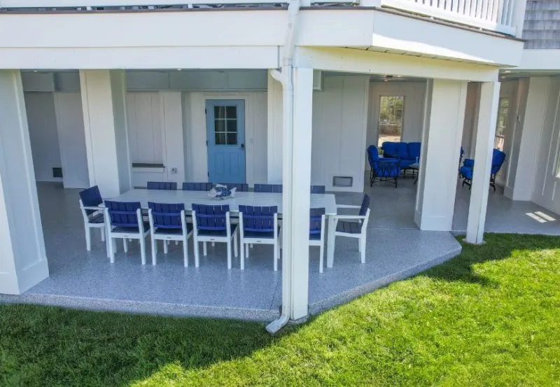 an outdoor patio area with concrete flooring that has been coated with a durable, light-colored material.