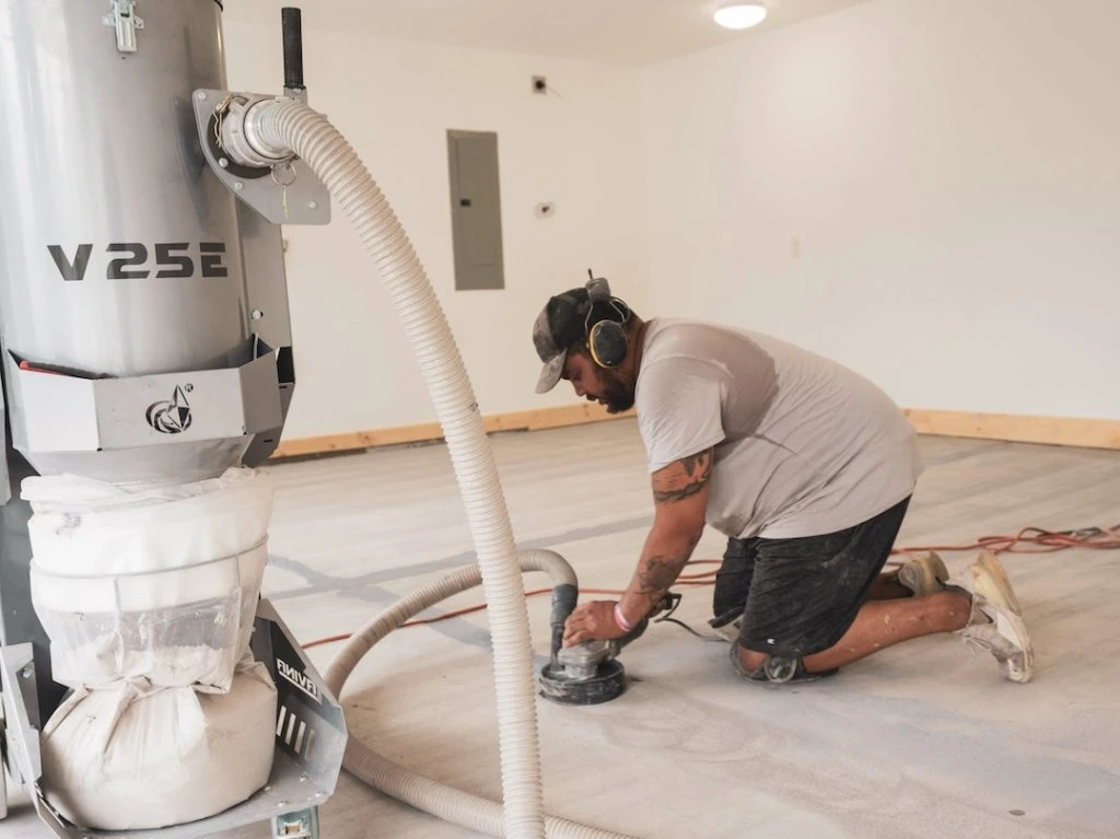 man grinding out concrete floors from previous concrete paint chips