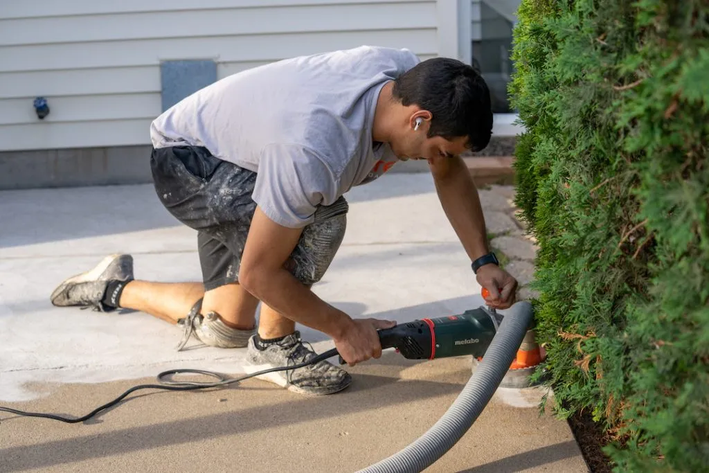 man grinding concrete patio down to apply polyurea coating